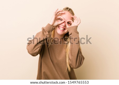 Cute and natural teenager woman showing okay sign over eyes