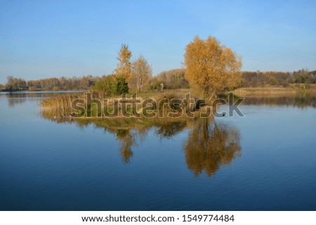 autumn landscape lake shore reflection and person walk blue sky background 