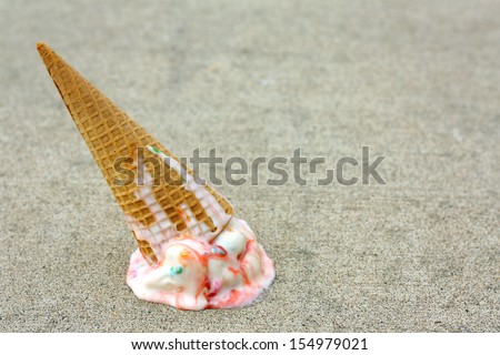 A rainbow colored ice cream cone has dropped upside down on the sidewalk on a summer day Royalty-Free Stock Photo #154979021