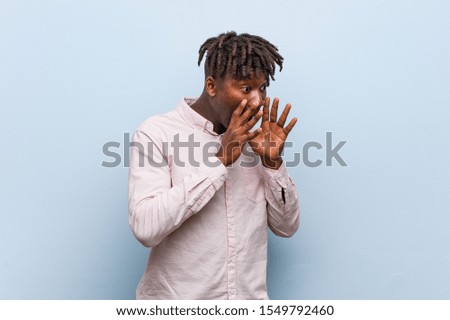 Young business african black man shouts loud, keeps eyes opened and hands tense.