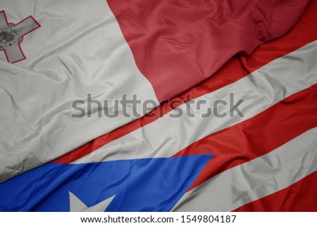 waving colorful flag of puerto rico and national flag of malta. macro
