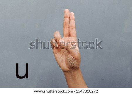  Hand Showing Sign of U Alphabet, isolated on grey background. Sign language                             