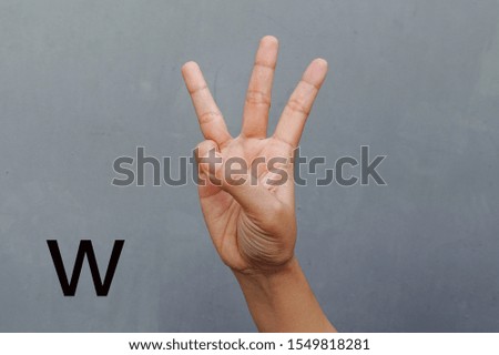  Hand Showing Sign of W Alphabet, isolated on grey background. Sign language                             