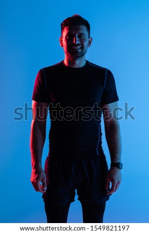 Attractive fitness man in sportswear on pink light background
