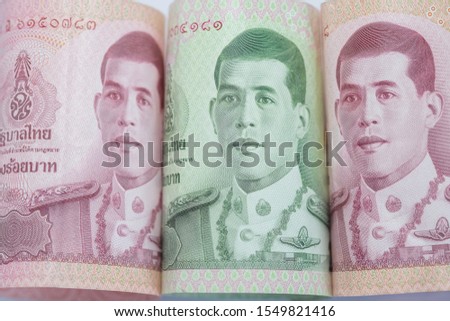 Row of Thai money bank note red green background. Business concept, finance. Thai word is Thai government and Hundred baht.