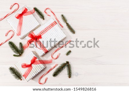 Christmas background. Gifts, fir tree branches, red decorations on white wooden background. Christmas, winter, new year concept. Flat lay, top view, copy space