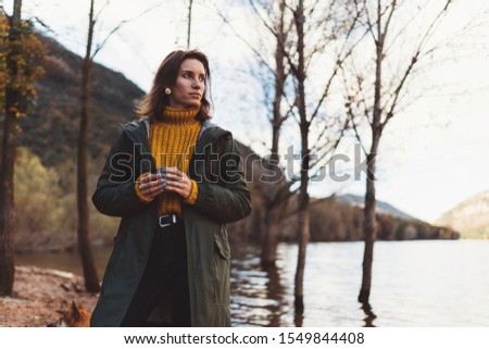 tourist traveler girl relax drink tea on background mountain,  woman rest on lake shore nature trip, holiday concept