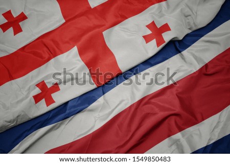 waving colorful flag of costa rica and national flag of georgia. macro