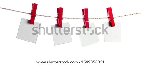 Set of four blank paper notes held on a string with clothespins isolated on white background