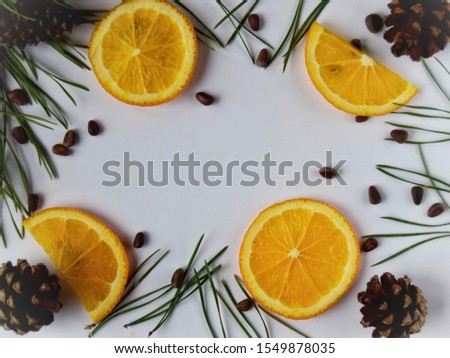 brown the pine nuts with slices of orange orange close up with a sprig of pine tree and cones on white background