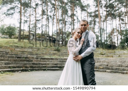Modern ceremony in European style. Beautiful wedding couple in atmospheric forest with rocks. 