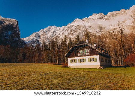 house in a field near the mountains