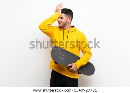 Handsome young skater man over isolated white wall has realized something and intending the solution