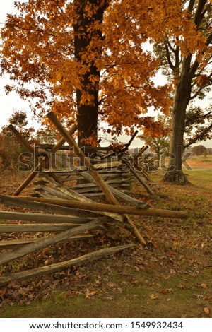 Split rail fence with orange autumn hardwoods at Gettysburg National Military Park, Pennsylvania, USA