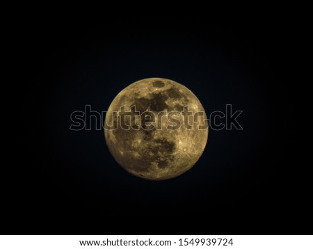 full moon with yellow tones on black background 