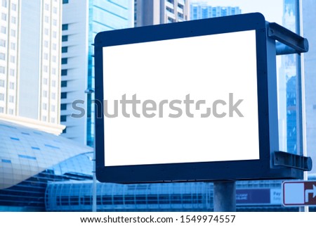 Advertisement mockup. Blank empty billboard on the city street in Dubai, UAE against skyscrapers. Blue toned
