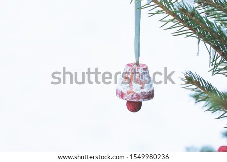 Handmade decoration on a Christmas tree outdoor, snow in the background. Diy creative ideas for children. Environment, recycle and zero waste concept. Selective focus, copyspace.