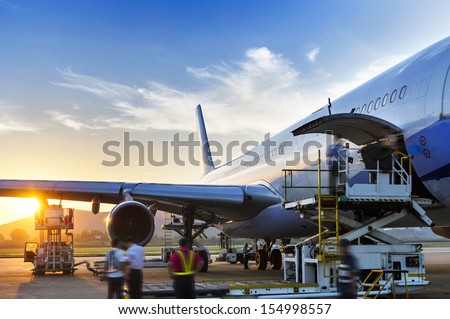 Airplane near the terminal in an airport at the sunset Royalty-Free Stock Photo #154998557
