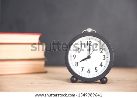 books with clock on the desk background