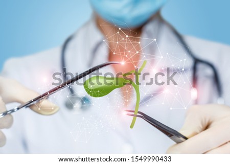 The concept of surgical treatment of the gallbladder. The doctor handling of the gall bladder on blurred background. Royalty-Free Stock Photo #1549990433