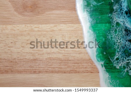 Decorative board with a picture of a sea wave made of epoxy resin, a beautiful blue and emerald hue, imitation of sea foam.