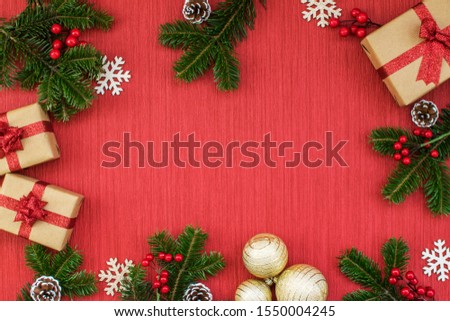 Christmas composition with gifts, golden balls, pine cones, fir branches, mistletoe and snowflakes on a red background