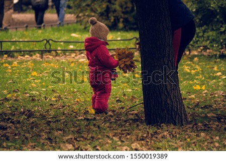 Mom playing with daughter child in autumn park. Happy moments together