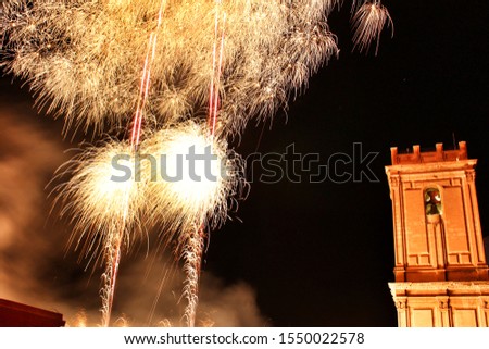 Colorful Fireworks in pyromusical show next to the bell tower of Santa María church in Elche