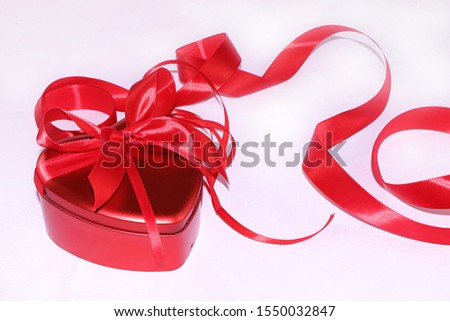 Red gift box with festive ribbon, Christmas or New Year background, Valentine's day, selective focus. Preparation for a happy congratulation, festive atmosphere, surprise