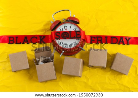 The concept of the inscription Black Friday placed on a red ribbon with a clock, On a crumpled yellow cardboard