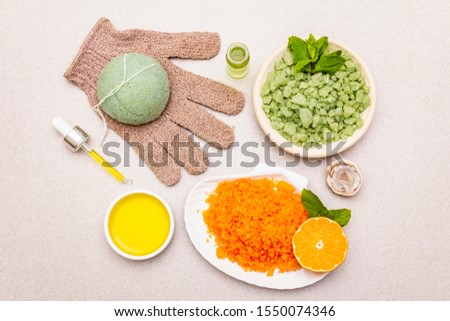 Healthy self-care. Minimalistic organic lifestyle. Comfort and natural pharmacy. Set of sea salt, herbal oil, glove, mandarin and fresh mint leaves. Bowls, stone background, top view, close up