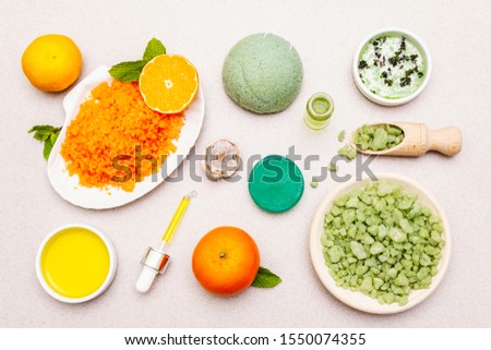 Healthy self-care. Minimalistic organic lifestyle. Comfort and natural pharmacy. Set of sea salt, herbal oil, mandarin and fresh mint leaves. Bowls, stone concrete background, top view, close up