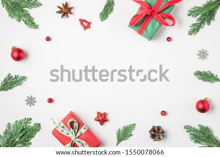 Christmas frame made of fir branches, gift boxes red holiday decorations and pine cones on white background. Christmas or Happy New Year concept. Flat lay. top view with copy space
