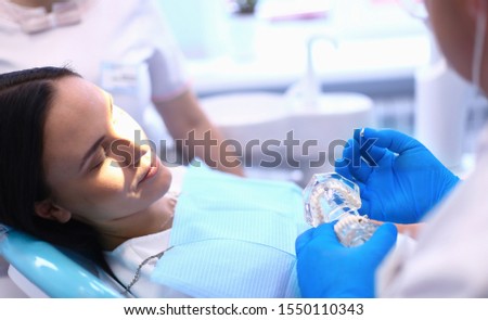 Portrait of a dentist who treats teeth of young woman patient