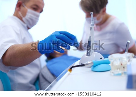 Detail of hand holding dental tools in dental clinic. Dentist Concept