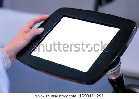 Close up view: woman using floor standing tablet kiosk with blank white display at exhibition, training classroom, museum. Education, white screen, mock up, copyspace, template, isolated concept