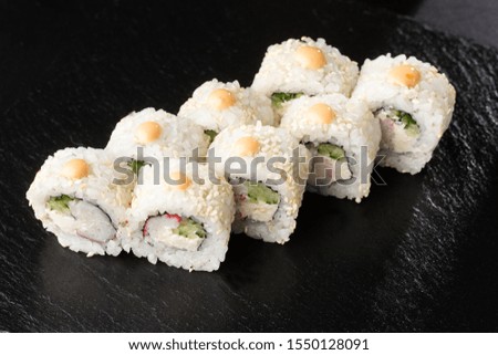 Sushi Rolls with shrimp , cucumber and cream cheese inside on black slate isolated. California rolls covered white sesame seeds. Sushi menu. Horizontal photo.