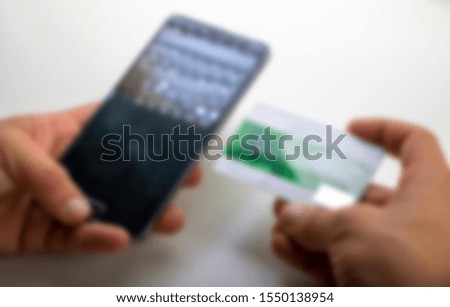 Shopping by phone with credit card in blurred background