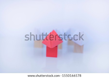 Leadership concept with red paper ship leading among group of white ships on white background.