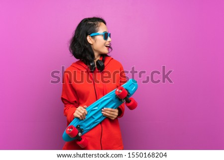 Asian young girl with skate over purple background