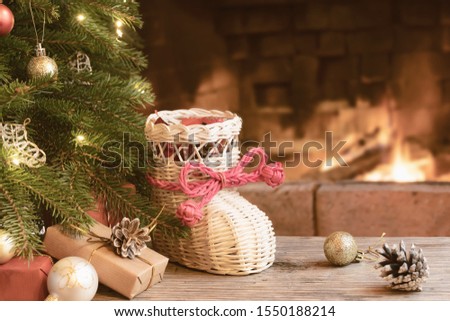 Gifts and whisker stocking under the Christmas tree in the room with a fireplace on Christmas eve.