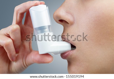 Woman uses an inhaler during an asthma attack, close-up Royalty-Free Stock Photo #155019194