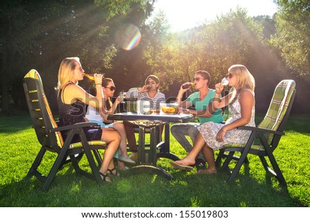 Group of young friends enjoying a garden party on a sunny afternoon Royalty-Free Stock Photo #155019803