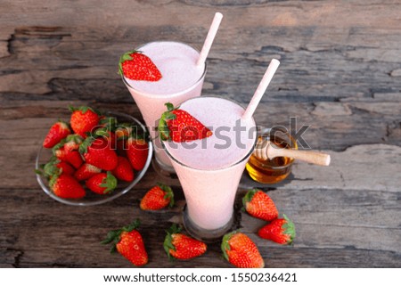 Strawberry smoothies colorful fruit juice milkshake blend beverage healthy high protein the taste yummy In glass,drink episode morning on wood background.