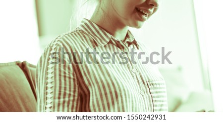 Happy brunette woman sitting on sofa with laptop