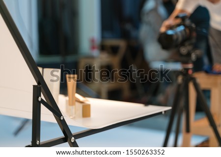 Shooting cosmetic product pack shot in photography studio with lighting equipment