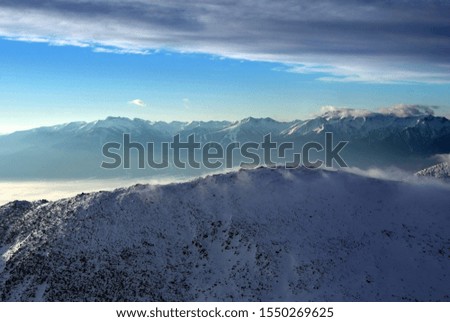 Mountain background with sky, clouds and snow. Sunny morning and a high peaks.