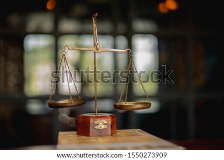 Law books and Scales Of Justice On table In Law Office.