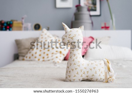 Unicorn soft toy for children on the bed in the bedroom