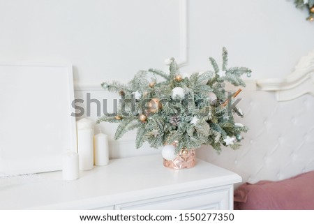 Beautiful Christmas composition of a Christmas tree with toys in the interior of a bright white bedroom, dining room or living room in the house